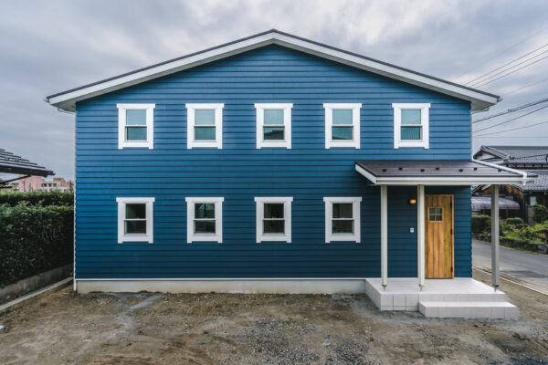 California style house with midnight blue wrap siding