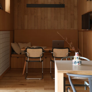 半個室の打ち合わせスペース。 木目調の落ち着いた空間で、テーブル奥は柔らかいソファ。 各ブースにはモニターが設けられている。